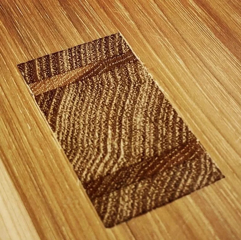 Close-up of a through tenon set into the hickory top, end grain showing against the long grain of the surface.