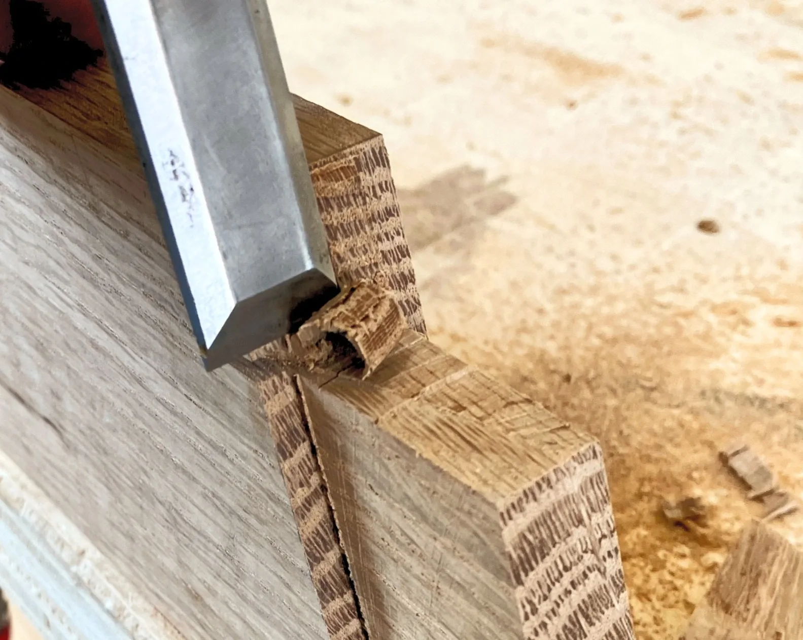 A chisel paring the shoulder of a tenon in white oak.