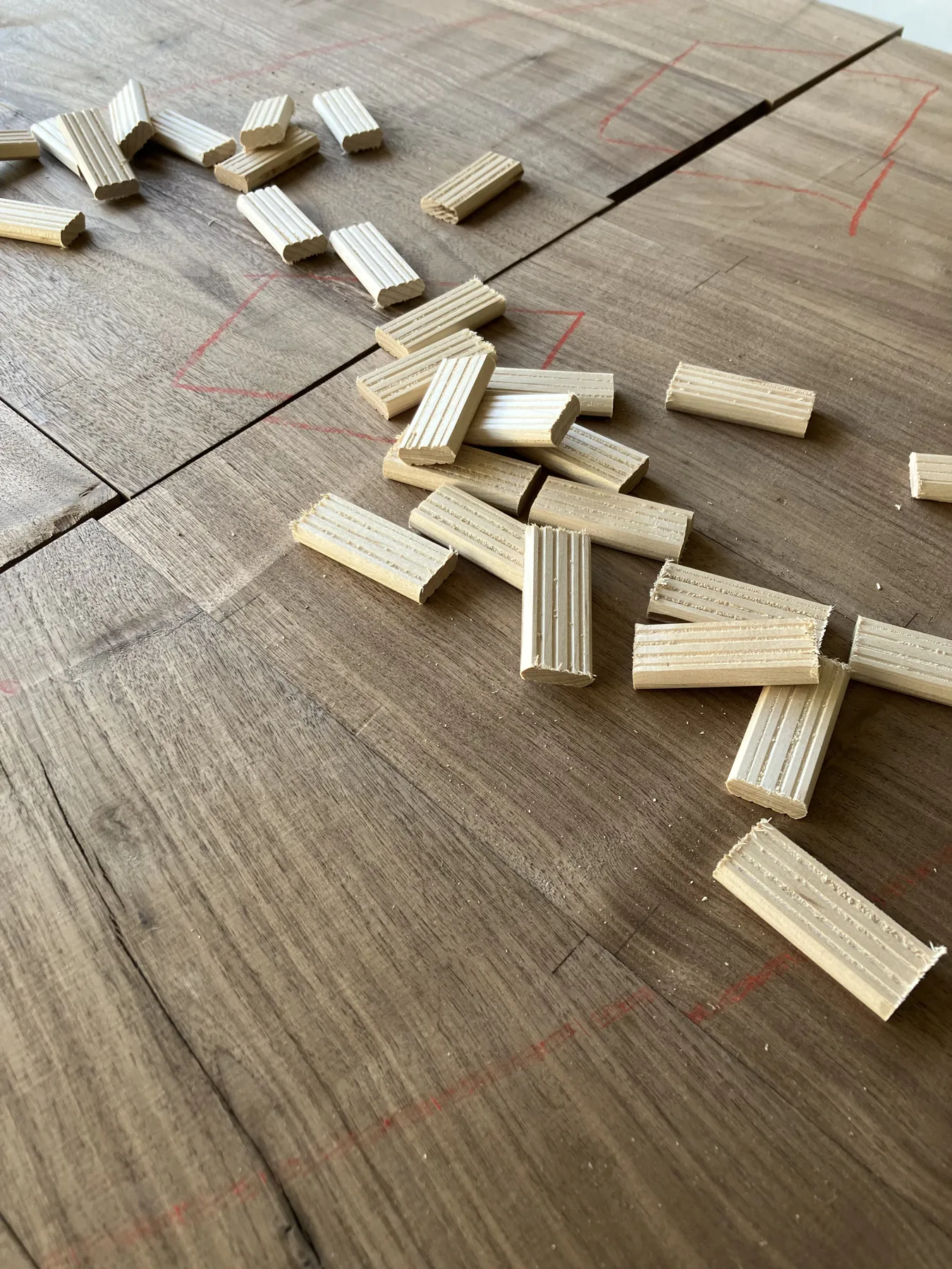 Loose tenons cut in quantity, laid out ahead of a walnut glue-up.