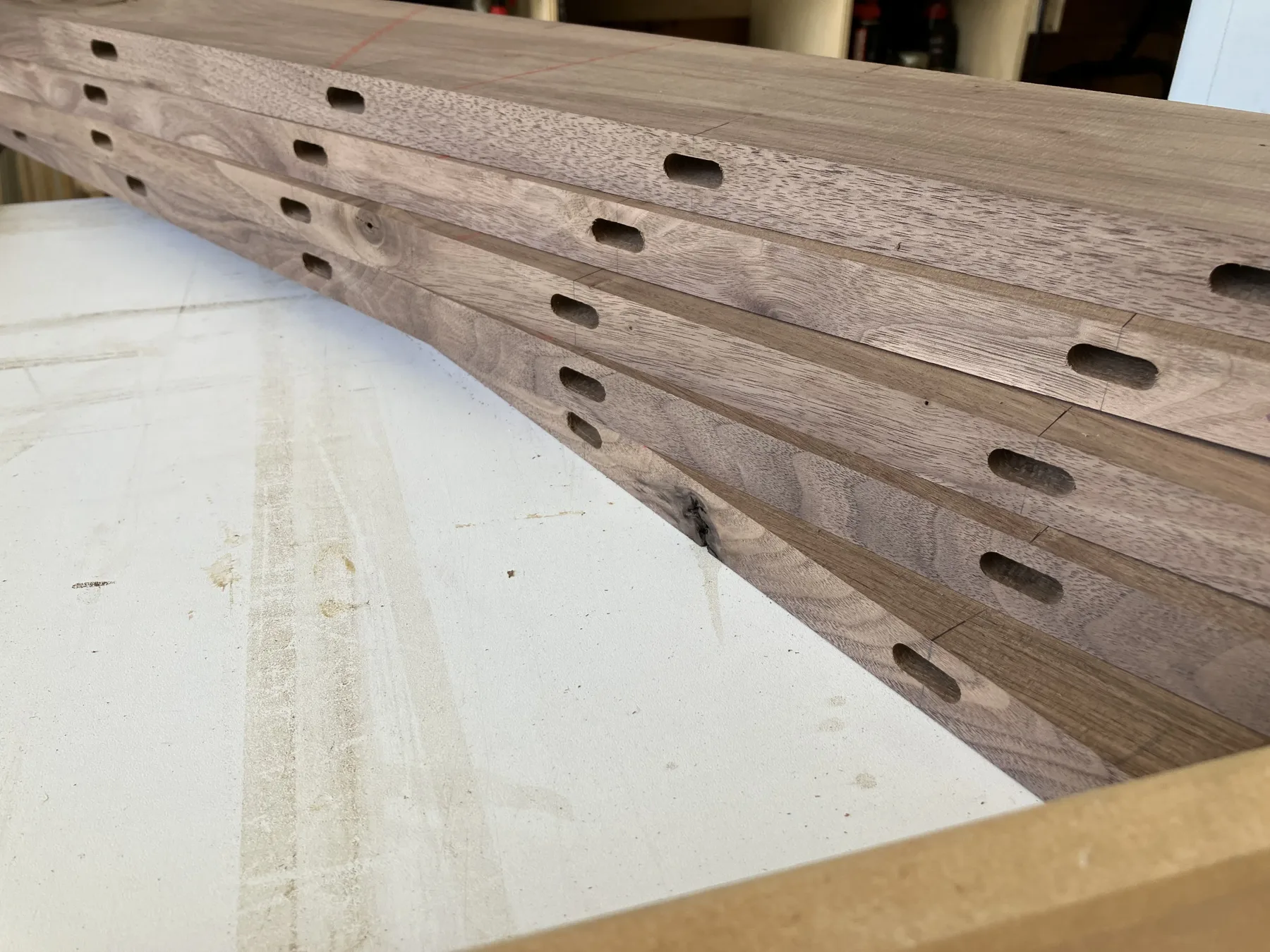 Mortises cut into walnut stock, laid out before the tenons are fit.