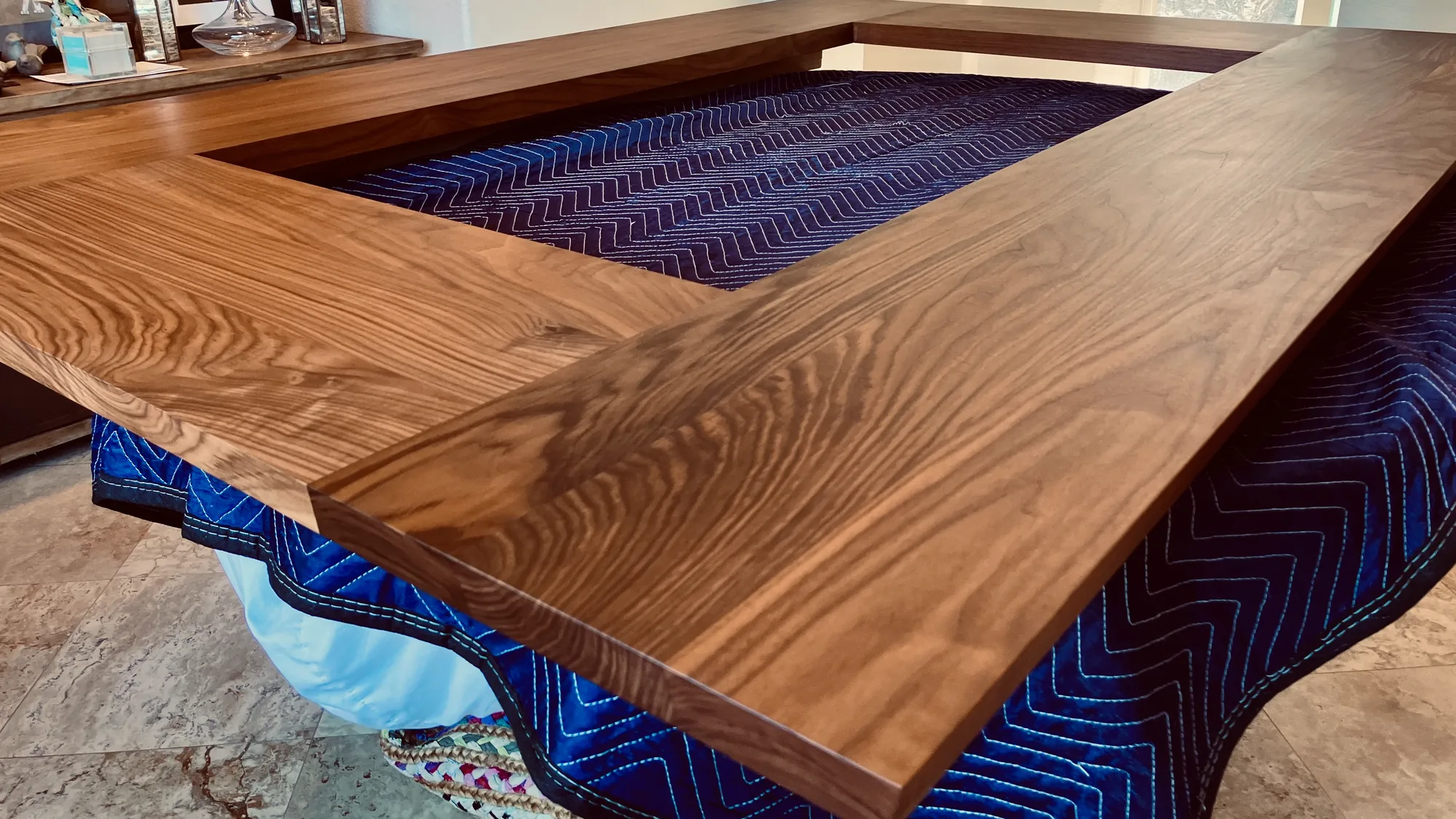 A walnut tabletop frame around an open center, long grain running the length of each rail.